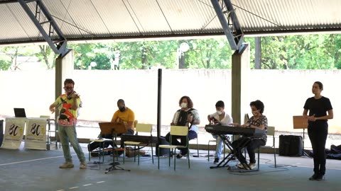 Vídeo: o grupo toca na quadra coberta; Roney Marczak de pé, com o violino.